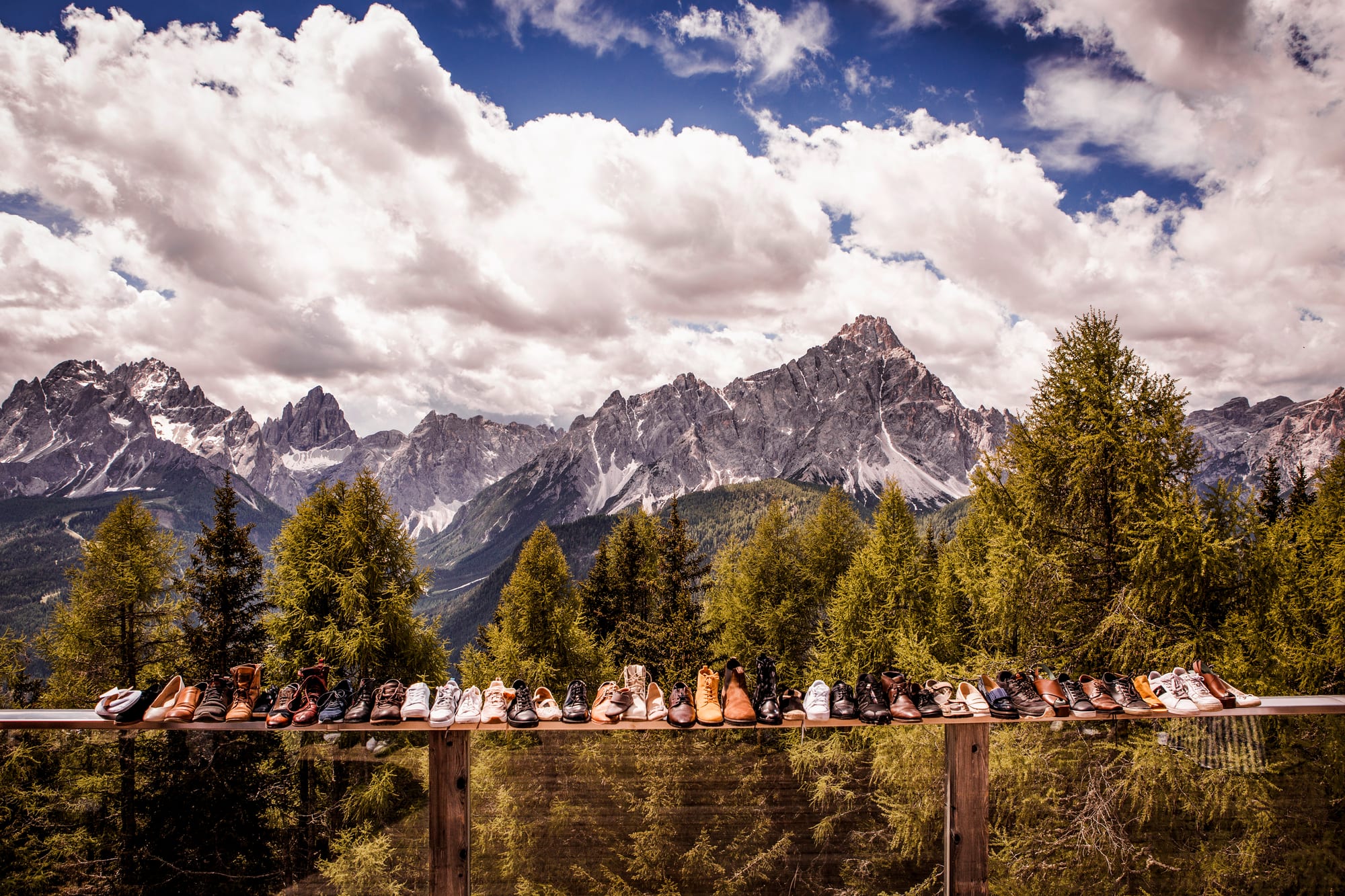 Schuhe aller Hochzeitsgäste auf einem Geländer mit Lienzer Dolomiten im Hintergrund